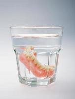 conjunto de dentaduras postizas en un vaso de agua