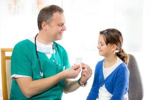 doctor gives a pill to girl photo