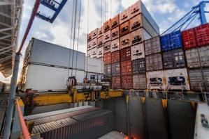 Port crane lifts container during cargo operation photo
