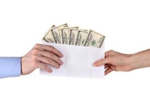 La mano del hombre pasa el sobre con dólares sobre fondo blanco. foto