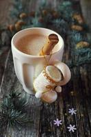 café con leche, decoraciones para árboles de navidad y ramas de pino foto