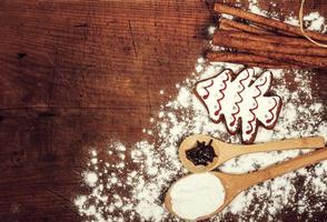 Christmas cookies, spices and flour on wooden chopping board