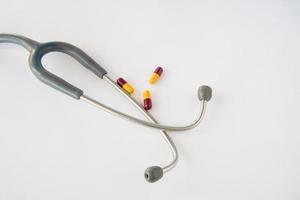 Stethoscope and pills on white background. photo