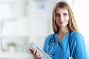 Portrait of woman doctor with folder at hospital corridor