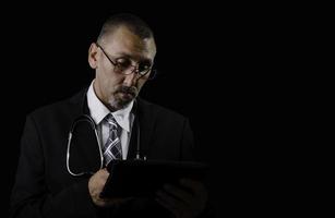 Médico, consultor, cirujano, aislado en un fondo negro foto