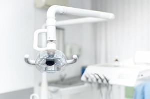 Dental light stand next to dentistchair and tools photo