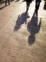 Asian businesswoman walking in street with long shadows photo