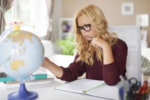 Focus girl studying globe of earth at home photo
