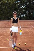 Young girl playing tennis on court photo