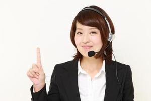 mujer de negocios japonesa de call center presentando y mostrando algo foto