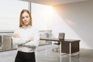 Young beautiful business lady with crossed hands in the office