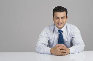 Businessman smiling with hands clasped