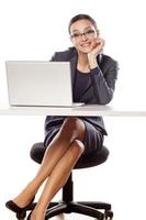 Smiling business woman sitting at the table with laptop