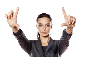 Positive business woman shows with her fingers in the blank