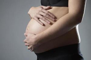 mujer embarazada con las manos sobre la barriga foto