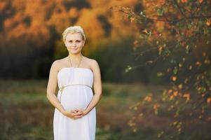 Young  pregnant woman in greek dress posing. photo