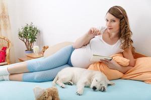 Pregnant woman with her dog at home photo
