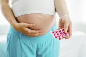 Pregnant woman with pills photo