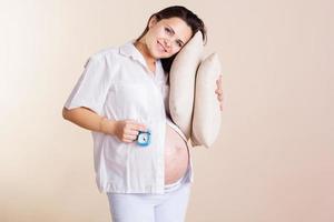 Pregnant woman in pajamas with pillow