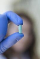 mujer sosteniendo cápsulas de píldora azul foto