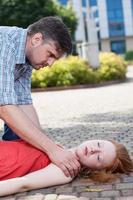Man helping unconscious woman