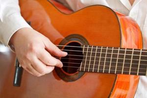 man playing classical acoustic guitar photo