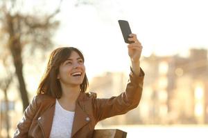 Mujer tomando foto selfie con un smarphone en invierno