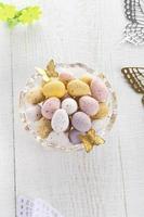 chocolate speckled eggs in bowl with batterfly on white table photo