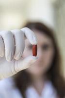 Doctor holding red pill capsule photo