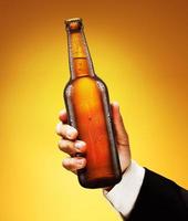 botella de cerveza en la mano de un hombre foto