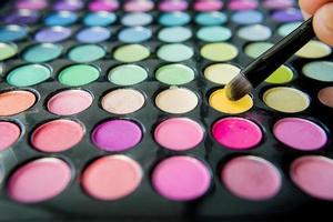 Pallet of colorful eye shadows and make up brush photo