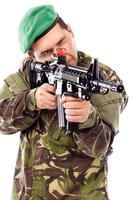 Retrato de un joven soldado apuntando con una pistola foto