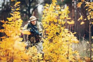 soldado con rifle en el bosque