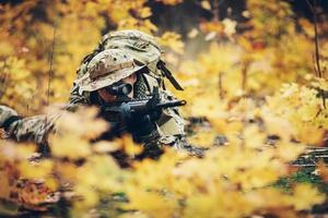 soldier with rifle in the forest photo