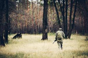 soldado con rifle en el bosque