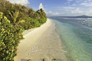 Deserted tropical island beach turquoise ocean lagoon palm trees photo