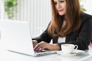 Asia mujer en café con laptop y café, concepto de negocio