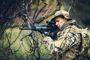 soldado con rifle en el bosque foto