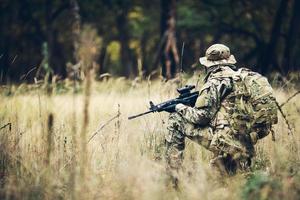 soldier with rifle in the forest photo