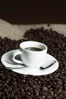 Cup on coffee beans photo