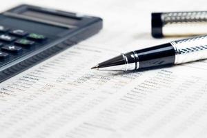 business pen, calculator on financial chart