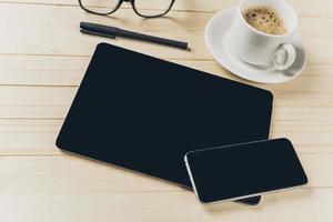 teléfono móvil y tableta con notebook en el escritorio foto