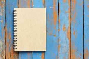 Brown notebook on wooden background photo