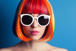 beautiful woman wearing colorful wig and white sunglasses agains photo