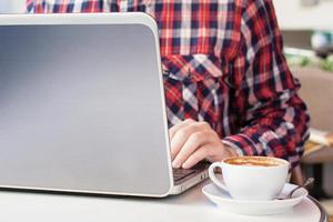 hombre de negocios trabajando en la computadora sentado en el café de la ciudad