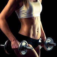 Fitness girl - attractive young woman working out with dumbbells photo