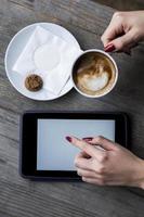 Woman' s hand holding coffee and search on tablet photo