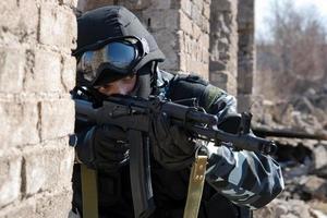 Soldado apuntando a un objetivo con un rifle automático foto