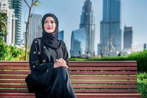 Arab success. Arab businesswomen in hijab sitting on bench photo