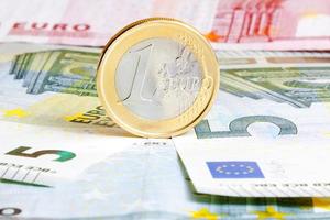 one euro coin on banknotes